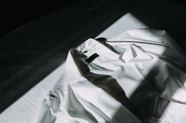 White shirt lying on the bed