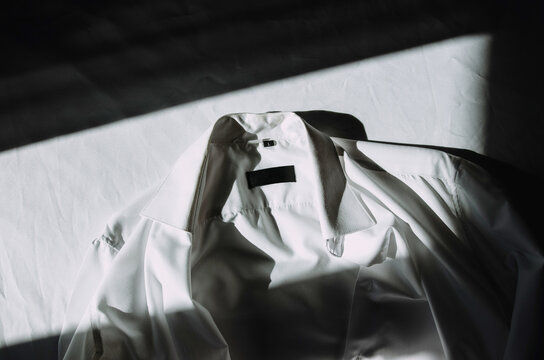 White shirt lying on the bed - Powered by Adobe