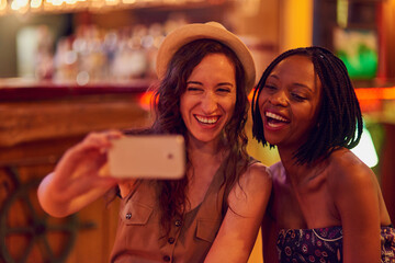 Fun times with my favourite person ever. Cropped shot of two young friends taking a selfie in a bar.