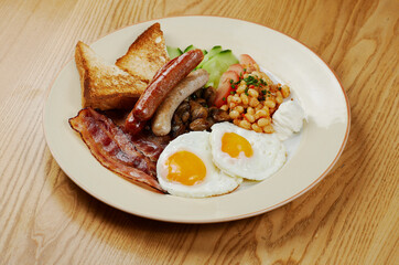 german breakfast of sausages, bacon, eggs and vegetables