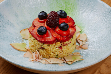 porridge garnished with strawberries and blueberries