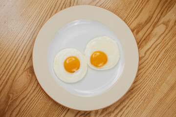 fried scrambled eggs from three eggs on a wooden table