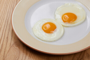fried scrambled eggs from three eggs on a wooden table