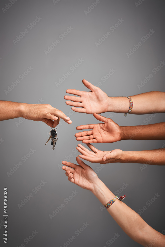 Poster Who wants to drive. Studio shot of unidentifiable hands reaching for a set of keys against a gray background.