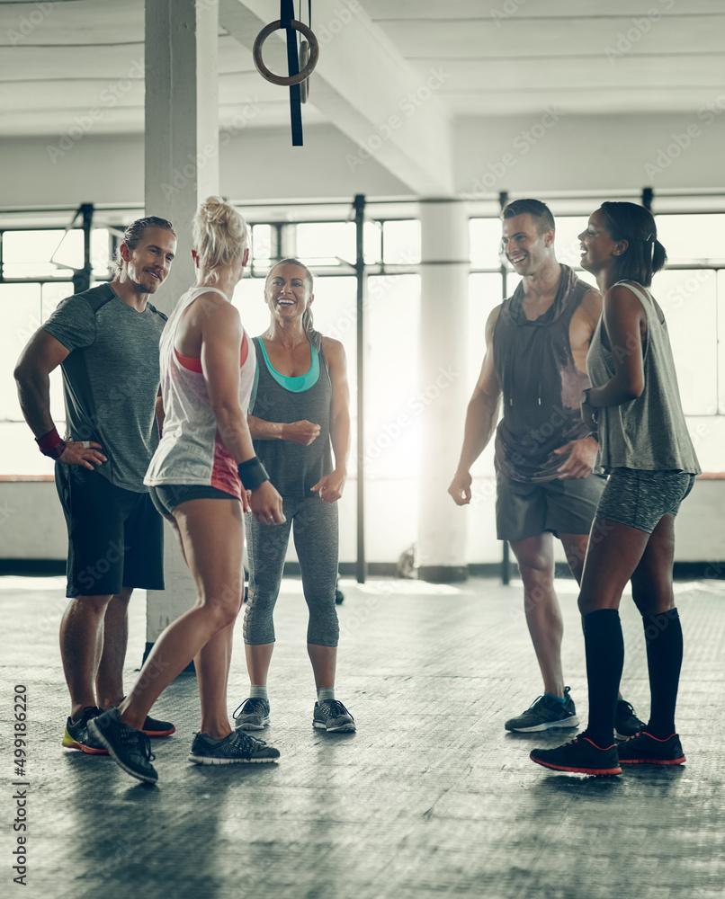 Poster supporting and challenging each other. shot of a group of young people working out together at the g