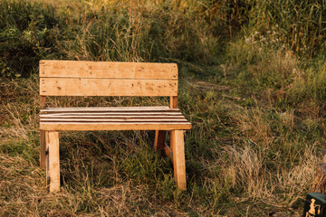 Wooden bench stands in the village in the grass