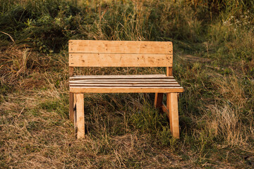 Wooden bench stands in the village in the grass