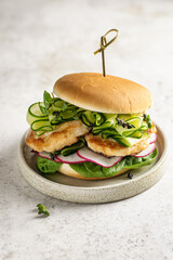 Homemade burger with meat, spinach, cucumber, radish and microgreens. Fast food close up