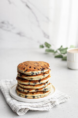 A stack of pancakes with fresh blueberries inside on marble. Delicious homemade breakfast.