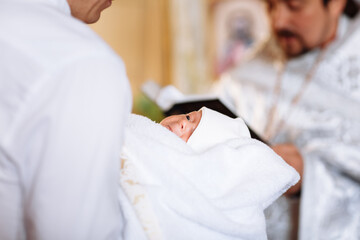 Fototapeta premium baptism of a child in the church. Ukrainian Orthodox Church. Orthodox baptism of a child. Church rite of acceptance of faith. The priest baptizes the baby