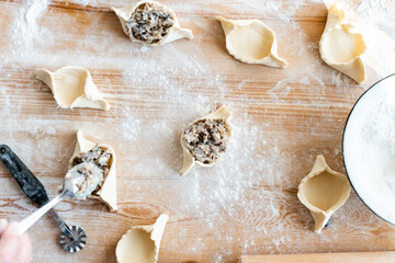 Cropped view of the unrecognisable person putting filling into the dish