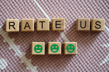 Rate us inscription on cubes and green smiling emoticons