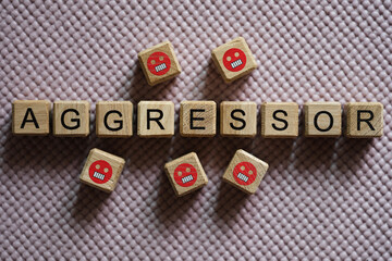 Text aggressor on cubes and angry emoticons closeup
