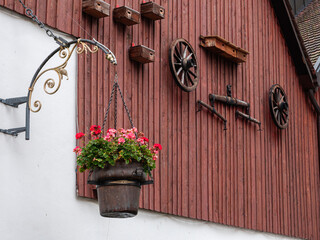 Fototapeta na wymiar Flower pot, wheels and decorations of an old farmhouse facade in Laufen, Switzerland