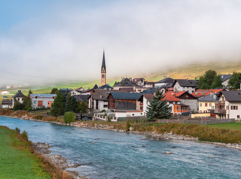River Inn and village of Zuoz, municipality in the Maloja Region in the Swiss canton of Graubunden. Idyllic autumn foggy mood,