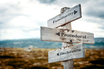 familiarity procedural declarative text quote written in wooden signpost outdoors in nature. Moody...