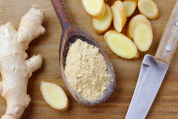 ground ginger powder in wooden spoon over rustic wooden table. Anti-inflammatory and antioxidant