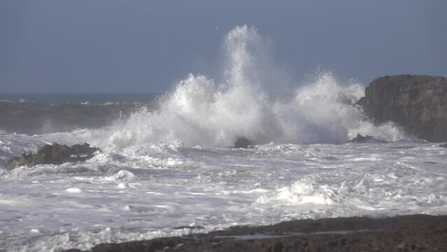 Splashes from atlantic ocean big waves over cliffs, slow motion