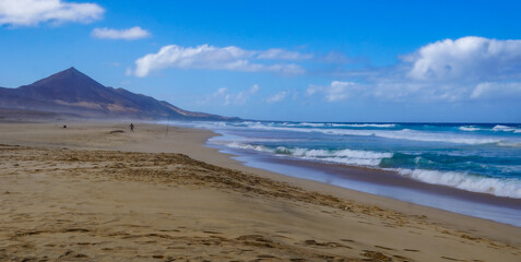 Cofete beach, Fuerteventura, Canarian Islands - wild nature landscape with lonely sandy beach, ocean waves and gorgeous mountains