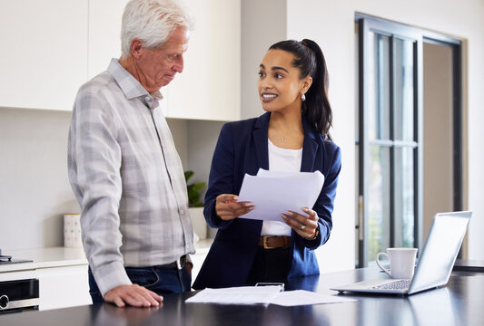 Your Finances Are Looking Good. Cropped Shot Of An Attractive Young Female Broker Going Over Some Paperwork With A Senior Male Client.