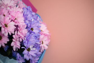 A bouquet of pink and purple flowers on a pink background with a place for text. Banner
