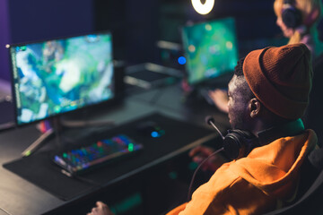concentrated young gamer in headphones playing video game in computer indoors eSport concept medium closeup . High quality photo