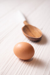 Brown chicken egg and a wood spoon.