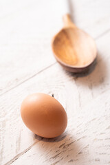 Brown chicken egg and a wood spoon.