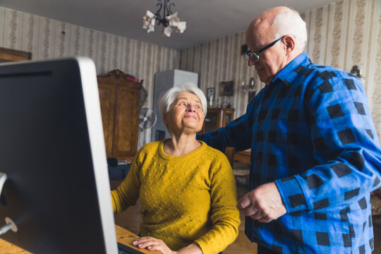 Pensioner Caucasian Couple Doing Online Shopping And Paying Their Bills Online Via Computer. Modern Seniors Concept. High Quality Photo