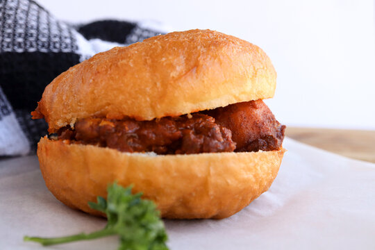 Traditional South African fried dough bread called a Vetkoek filled with chicken curry. Magwinya or Fat Cakes usually filled with mince curry or jam 