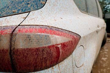 Detail of white cars very dirty from rains of mud, unwashed and neglected, covered in dust.