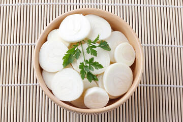 Sliced palm heart palmetto salad in ceramic bowl over rustic wooden table