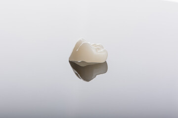 Qualified anatomic ceramic and zirconia crowns of human teeth close up macro isolated on black...