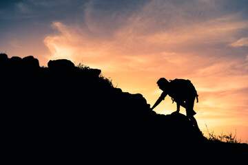 Mountain climber hiking up a steep cliff