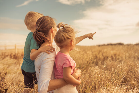 Mother And Her Children Exploring Nature. Family Lifestyle, Parenting  And Adventure 