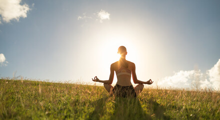 Meditation, peace of mind. woman meditating against a beautiful sunset 