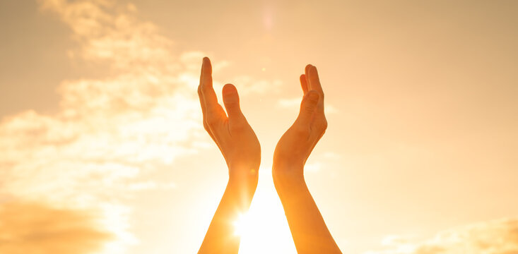 Person's hands up to the sun light. feelings of hope and happiness concept 