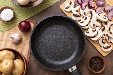 Cooking healthy vegan vegetarian food concept. Frying pan, sliced mushrooms and vegetables on kitchen table. Top view, flat lay