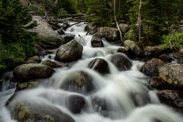 Naklejka na ściany i meble Water Rushes Over Boulders In Unknown Creek