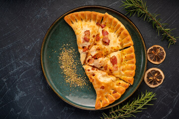 Delicious Pizza puff on black plate, Pizza puff on black plate on black background.