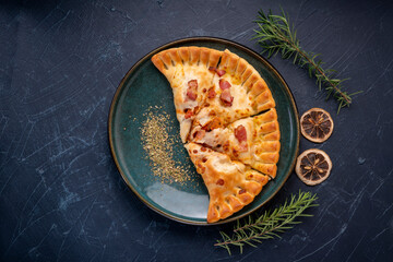 Delicious Pizza puff on black plate, Pizza puff on black plate on black background.