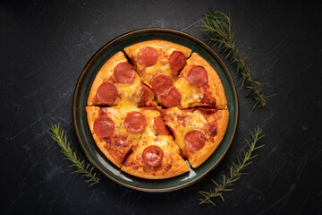 Hot and Spicy Pepperoni Pizza on black plate, Pepperoni Pizza on black plate on black background,