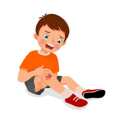 sad little boy has a knee injury crying holding his scratch bleeding leg with bruises after fell down