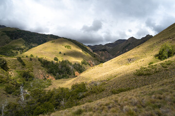 Mountain valley illuminated by sunbeams on a cloudy day, Chile