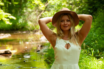 Girl in a white dress with sunflowers in the forest