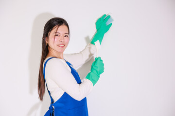 ゴム手袋をはめて掃除用具を持つ日本人女性