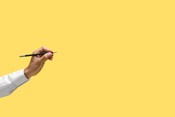 Male hand with pencil on color background