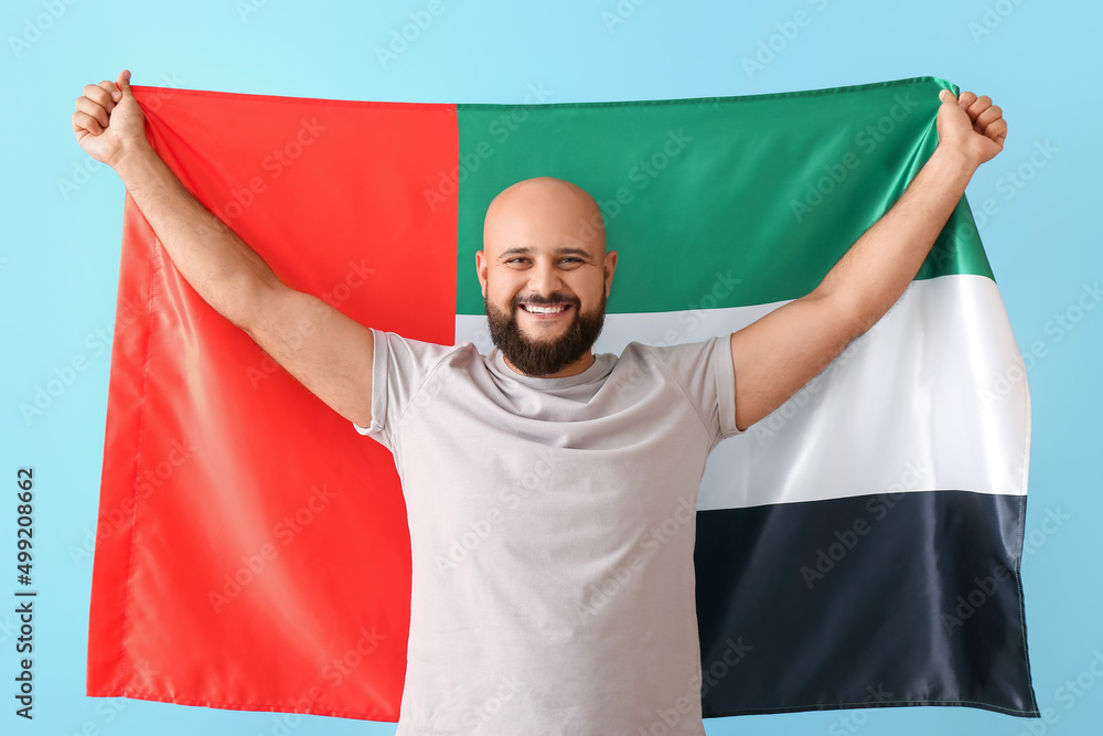 Wall mural man with the national flag of uae on color background