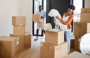 Moving can be such a mission. Shot of a young couple packing their belongings at home.