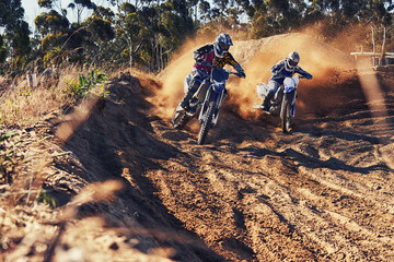 Fototapeta na wymiar Time to rip up this track. Shot of two motocross racers in action.